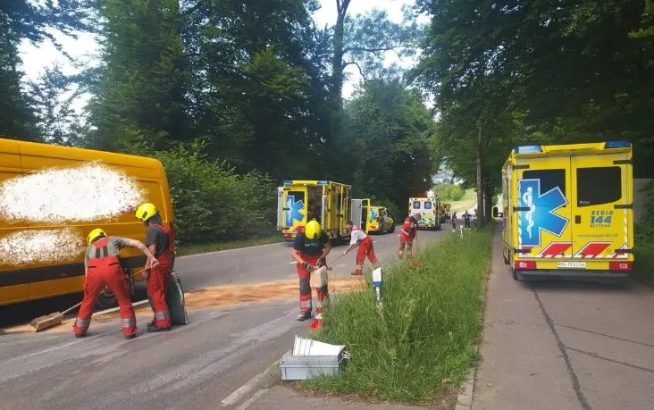 Feuerwehrleute schütten Bindemittel auf eine Strasse.